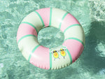 Pink and green inflatable ring with cartoon design in a pool